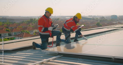 Wallpaper Mural Two engineers solar technicians in reflective gear discussing working examine solar installations on rooftop panels at dusk, with suburban backdrop Torontodigital.ca