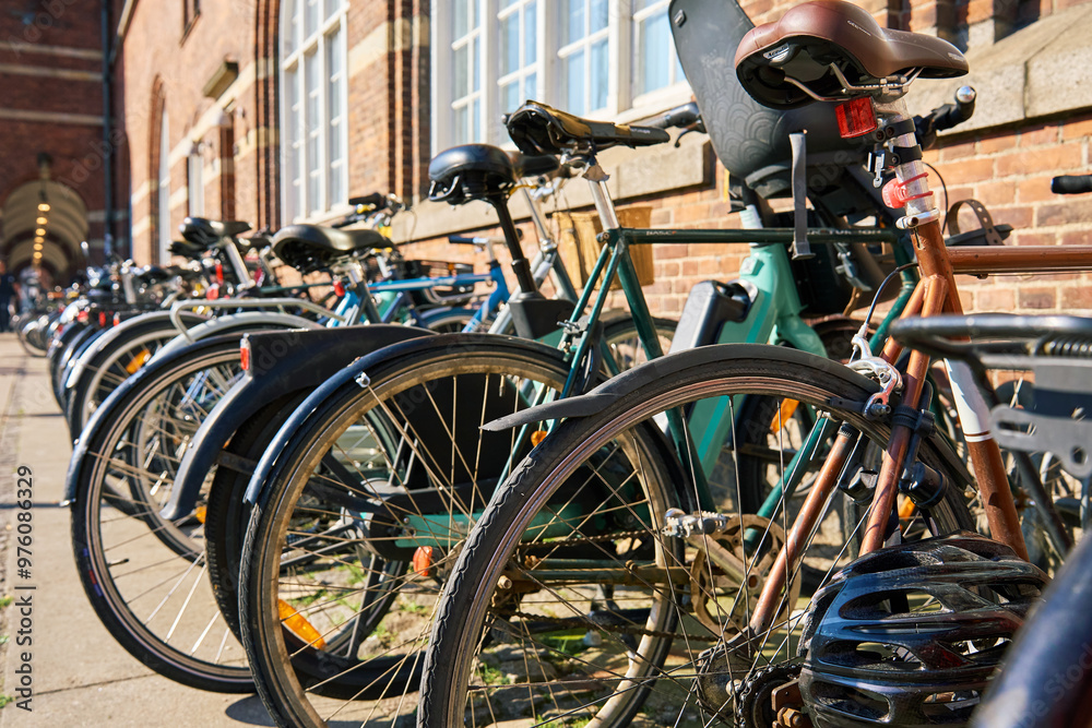 Obraz premium Many bicycles parked at a public bike rack in Copenhagen. Bike parking in Copenhagen. Concept of sustainable transportation and modern urban living in Denmark