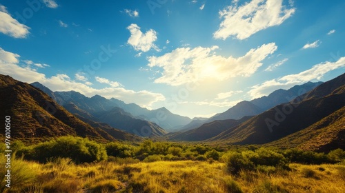 Majestic Mountain Valley Under a Blue Sky, showcasing breathtaking scenery, vast open spaces, rolling hills, lush vegetation, and a sense of peace and tranquility.