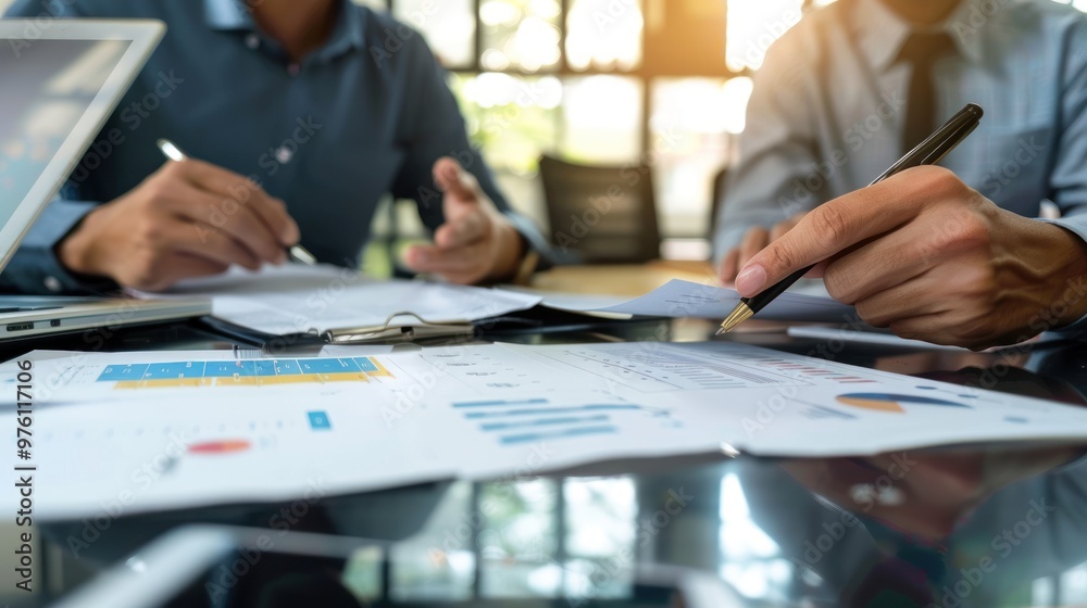 An office environment where team members are reviewing a document together An office environment where team members are reviewing a document together