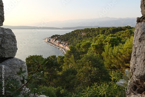 Scenic view of bay with coastal buldings of Novigrad town, northern Dalmatia, Croatia, summer late afternoon sunshine, viewed from walls of medieval fortress Fortica above town.  photo