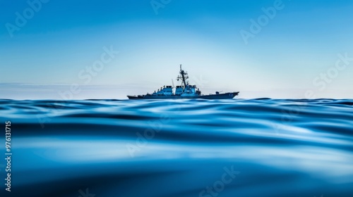 Naval ship cruising throughserene blue ocean underclear sky, showcasingmariti...