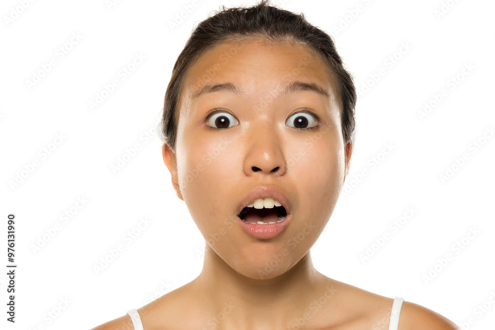 Portrait of a beautiful young surprised Asian woman posing on white studio background. Portrait of a beautiful young surprised Asian woman posing on white studio background.