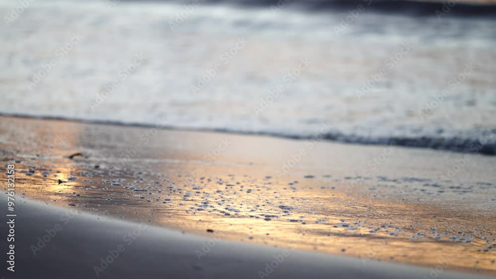 sunrise reflecting on the beach with golden light as waves roll in and water moves on the sand, calming waves sunrise reflecting on the beach with golden light as waves roll in and water moves on the sand, calming waves