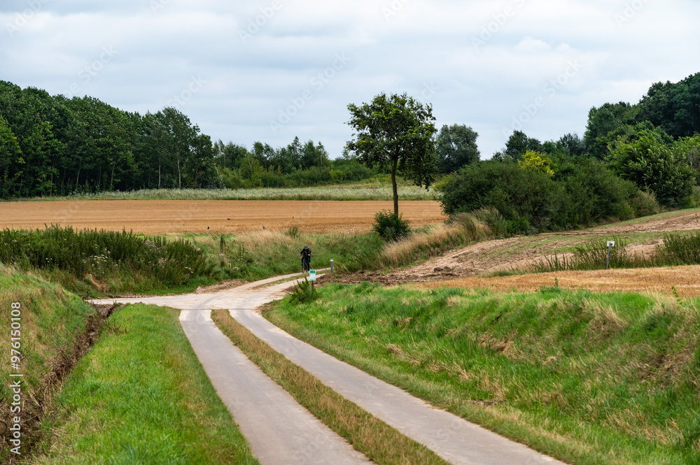 Winding road through the harvested fields and hills at the Flemish countryside around Breisem, Belgium Winding road through the harvested fields and hills at the Flemish countryside around Breisem, Belgium