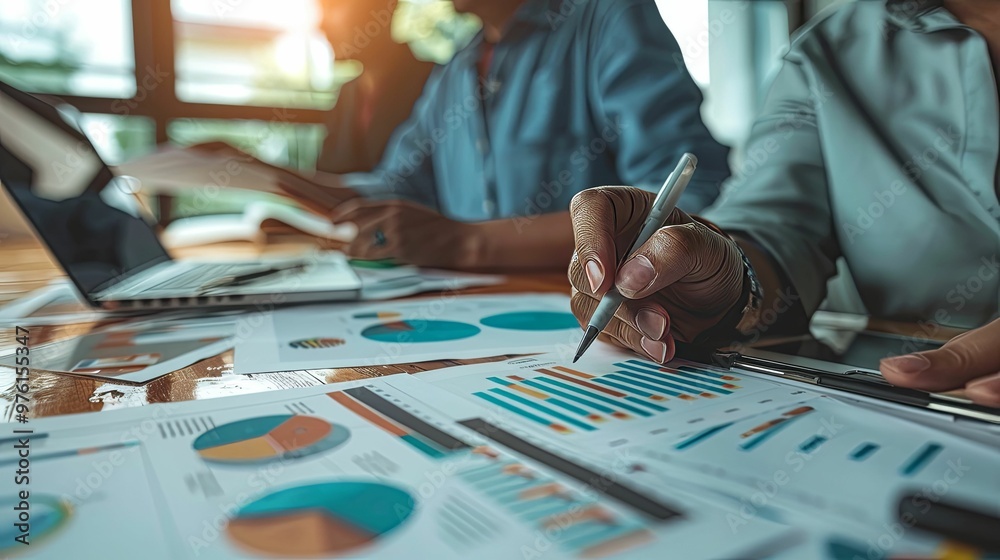 Close-up of a Hand Holding a Pen Pointing at a Business Chart