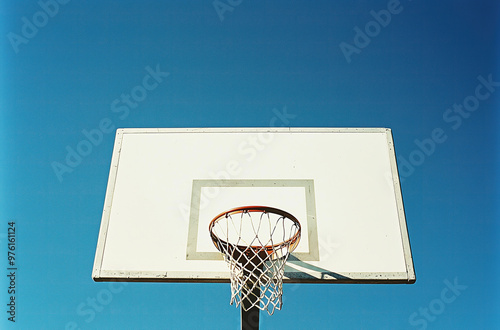 basketball hoop with a white backboard against a blue sky 