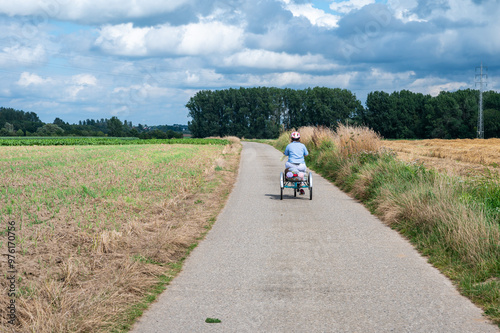 Portrait of a 41 yo woman with the Down Syndrome driving her tricycle in the fields, Hakendover, Tienen, Belgium