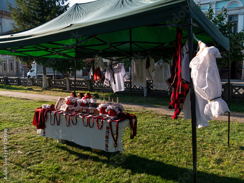 Dolls dressed in traditional Romanian folk costumes are set over embroidered materials and exposed for sale. Romanian culture Home decoration Handmade Folklore festival Europe travel Sighetu Marmatiei photo