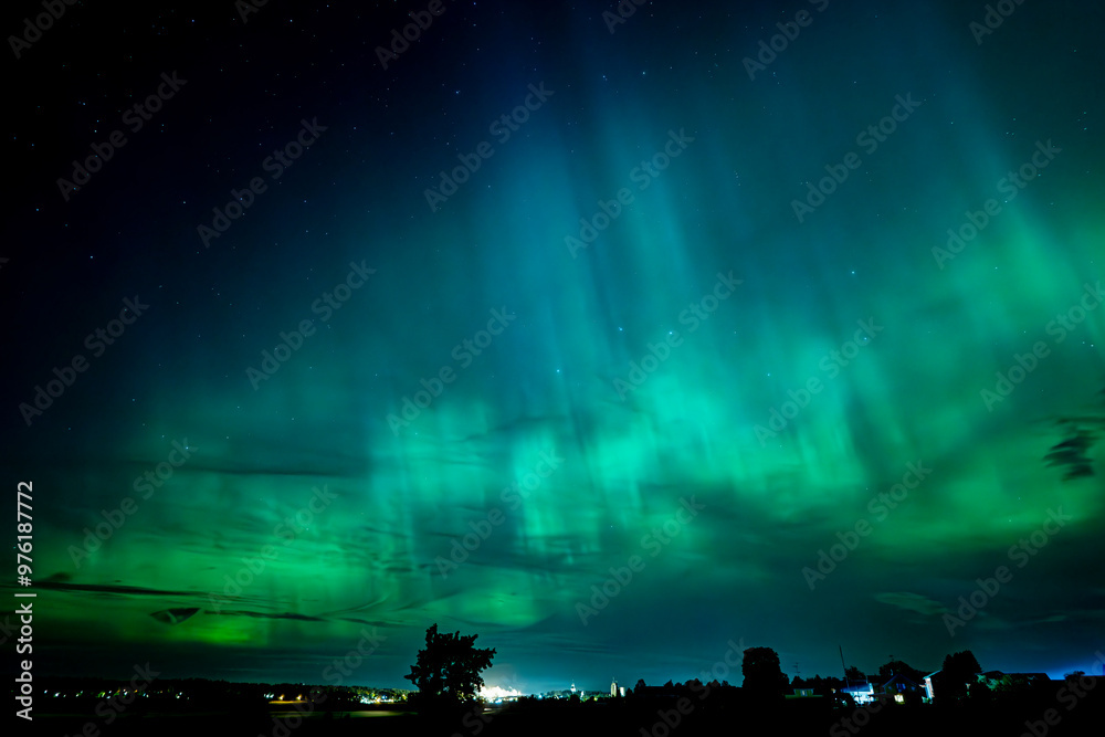 Fototapeta premium Northern lights dancing over the sky sky in the country road