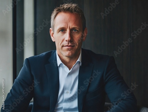 Confident businessman in modern office setting by window