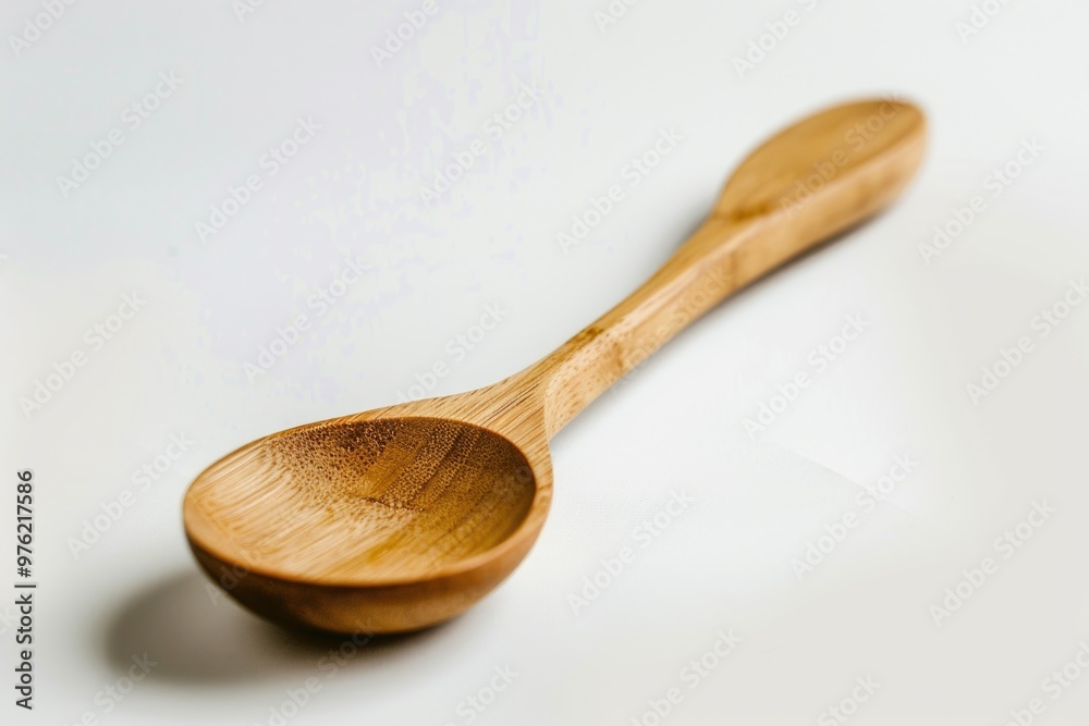 A simple wooden spoon rests on a flat surface A simple wooden spoon rests on a flat surface