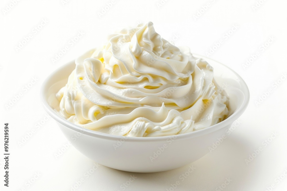 A bowl filled with fluffy whipped cream on a clean white surface, perfect for topping desserts or adding a touch of elegance to any setting A bowl filled with fluffy whipped cream on a clean white surface, perfect for topping desserts or adding a touch of elegance to any setting