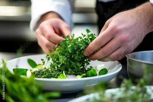 Chef garnishing dish with fresh herbs in professional kitchen setting