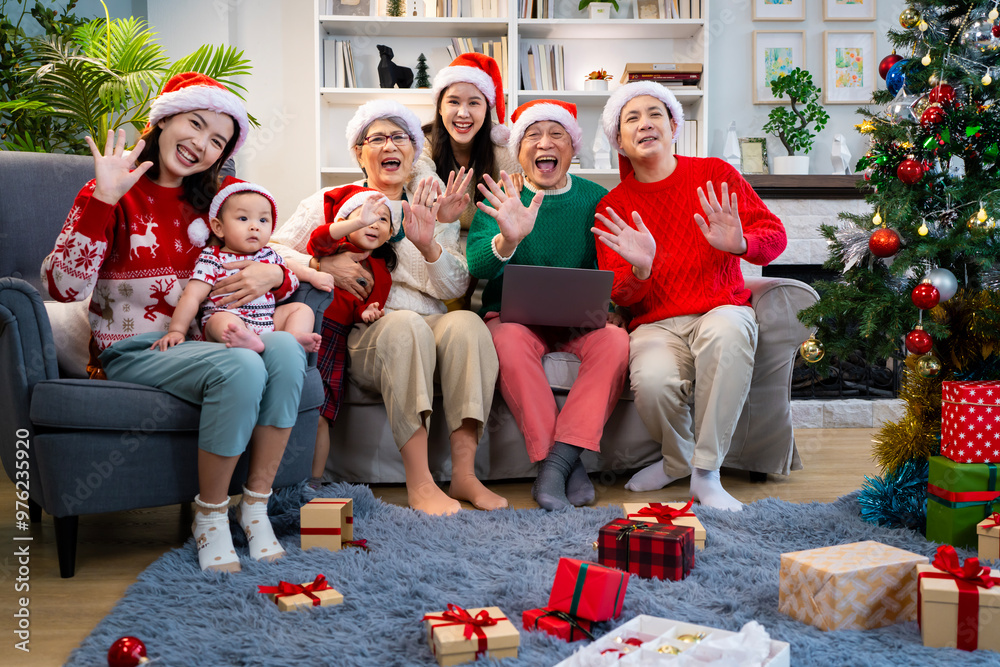 Asian family on Christmas Day. Everyone is happy together in a Christmas themed room filled with presents and orange lights. Asian family on Christmas Day. Everyone is happy together in a Christmas themed room filled with presents and orange lights.