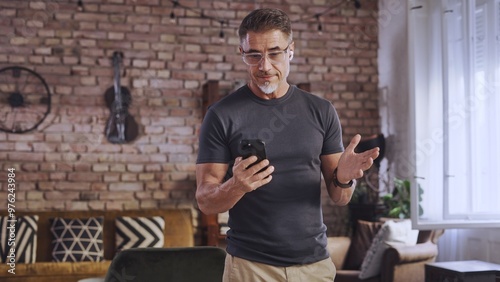 Mature man using smartphone at home. Businessman talking on video call with business partners. Freedom of digital work, telecommunication and connectivity in modern age. Entrepreneur remote working.