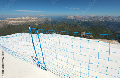 white protective tarp on the Marmolada glacier in Northern Italy to prevent melting and a safety net photo