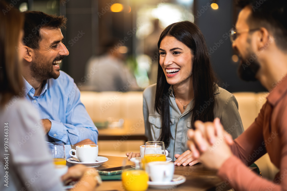 Group of friends hanging out at the cafe. The girl takes the lead in the conversation. Drinking orange juice and coffee. Group of friends hanging out at the cafe. The girl takes the lead in the conversation. Drinking orange juice and coffee.