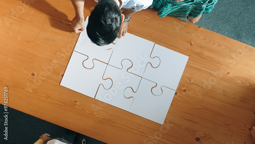 Φωτογραφία Top view of business man gathering last piece of jigsaw to complete puzzle