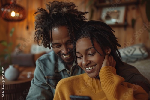 couple sharing a moment of joy as they look at a smartphone, the man embracing the woman from behind