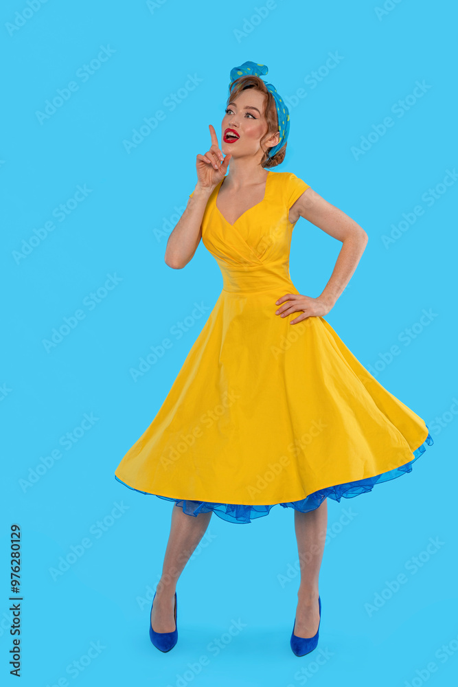 Woman in Vibrant Yellow Dress Strikes Playful Pose Against Bright Blue Backdrop Woman in Vibrant Yellow Dress Strikes Playful Pose Against Bright Blue Backdrop