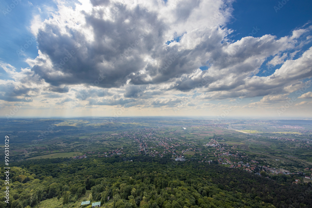Fototapeta premium A city with a lot of trees and a cloudy sky