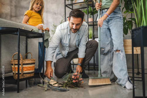 Family clean with brooms in a modern home filled with plants photo