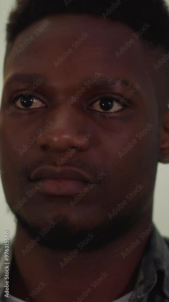 Tranquil young African-American man in checkered shirt sits in living room closeup slow motion. Attractive black guy model poses for camera Tranquil young African-American man in checkered shirt sits in living room closeup slow motion. Attractive black guy model poses for camera