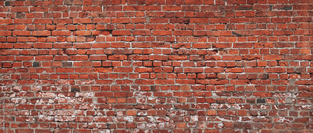 Naklejka premium A brick wall with a red color. The wall is made of bricks and has a rough texture