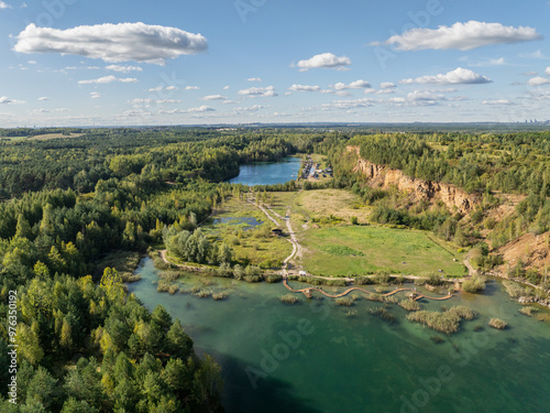 Aerial drone photo of Quarry turquiose lake colour, open pit mining in Park Grodek, Jaworzno. Poland. Turquiose Water and Wooden Bridge on lake. Polish Maldives Park Grodek in Jaworzno from drone.