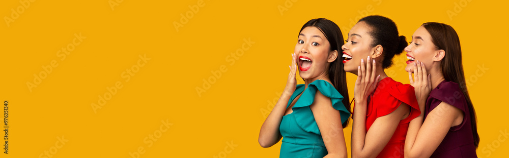 Gossip Girls. Three Diverse Models Sharing Secrets Whispering Standing Over Yellow Studio Background. Panorama Gossip Girls. Three Diverse Models Sharing Secrets Whispering Standing Over Yellow Studio Background. Panorama