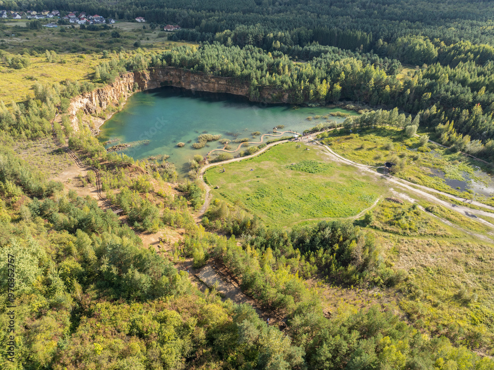 Obraz premium Aerial drone photo of Quarry turquiose lake colour, open pit mining in Park Grodek, Jaworzno. Poland. Turquiose Water and Wooden Bridge on lake. Polish Maldives Park Grodek in Jaworzno from drone.