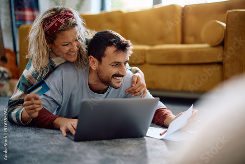 Happy couple paying their taxes online at home. photo