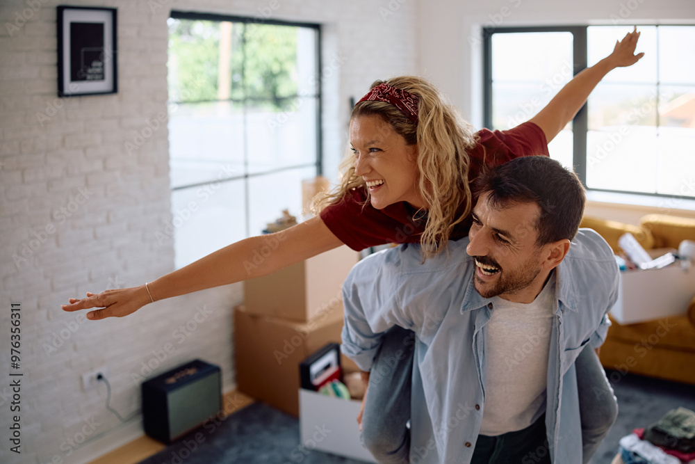 Obraz premium Carefree couple having fun after moving into new home.