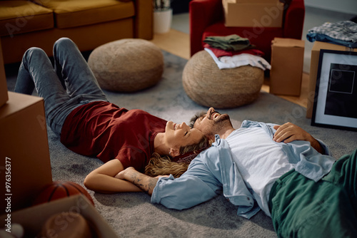 Carefree couple relaxing on the floor at their new house. photo