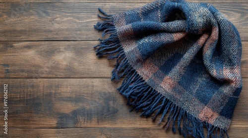 Cozy red and black plaid scarf elegantly draped on rustic wooden surface for ...
