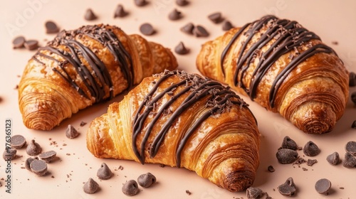 Freshly baked chocolate-filled croissants on a warm beige background showcasi...