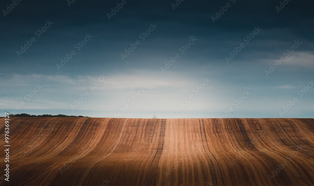 Naklejka premium A ploughed field is lit by a soft evening glow in the south of England