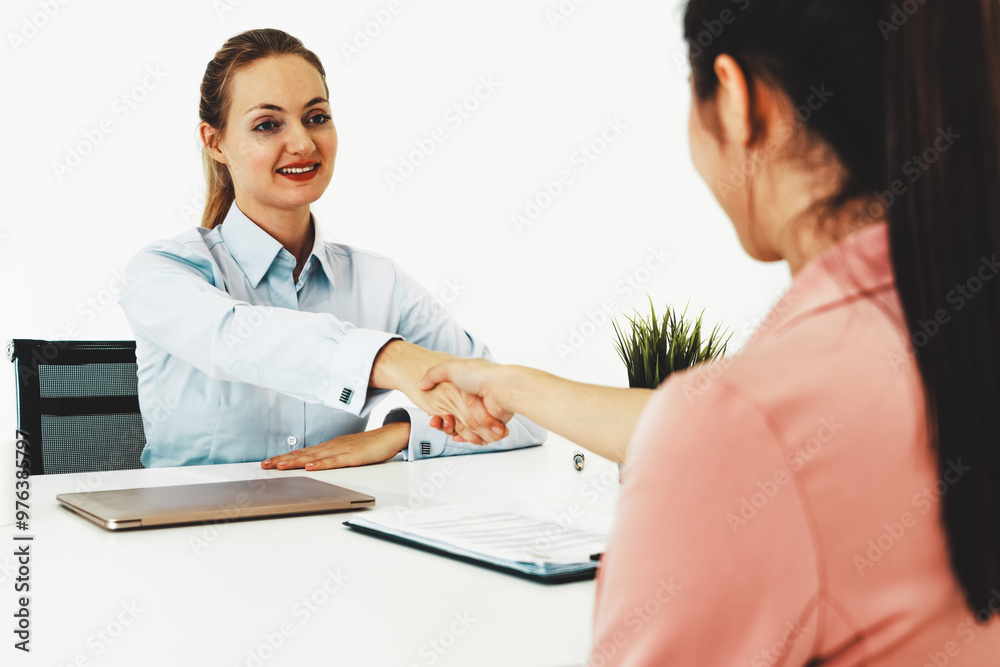 Two young business women in meeting at office table for job application and business agreement. Recruitment and human resources concept. uds Two young business women in meeting at office table for job application and business agreement. Recruitment and human resources concept. uds