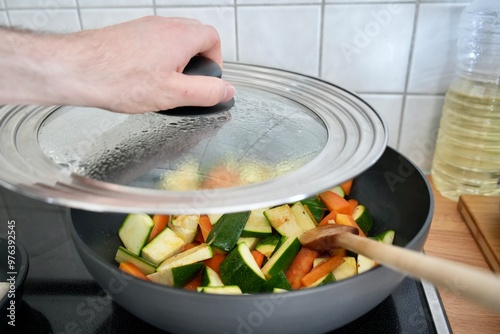 Person cooking fresh vegetables in the pan