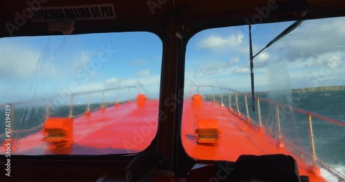 Stormy boat trip, red cutter through the Strait of Magellan, sea water lapping the bow, Patagonia, Chile, South America