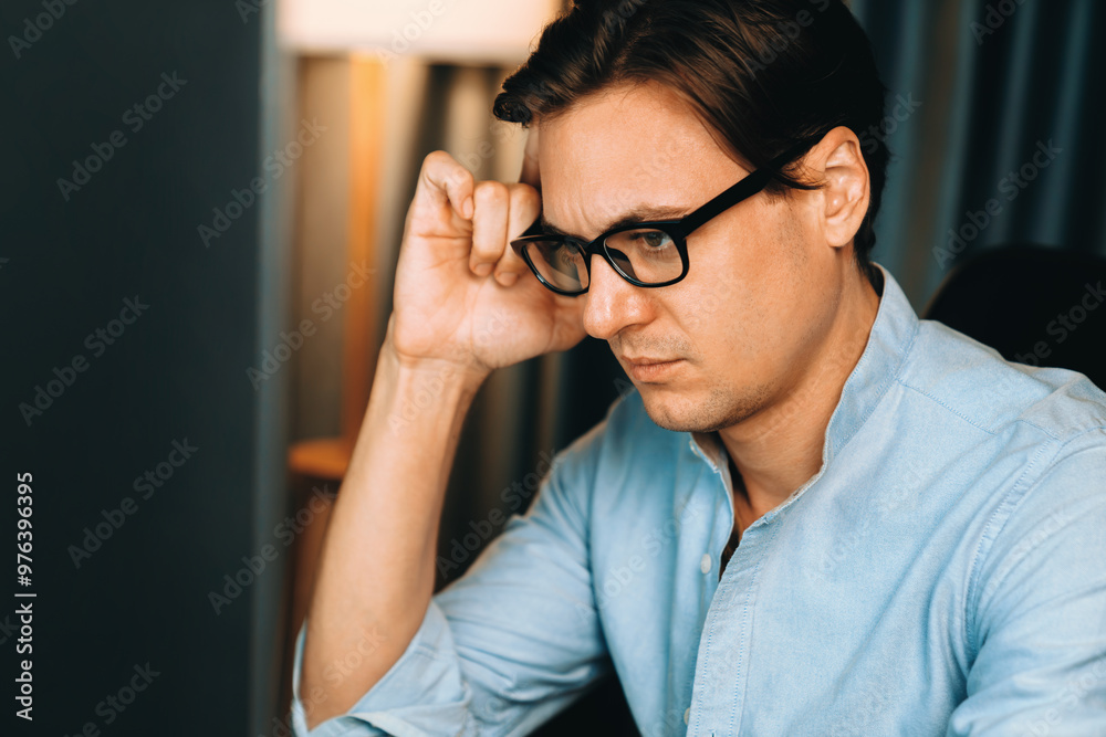 Thinking of stressful financial analyst researching on business paragraph on pc screen with dynamic database marketing analysis planning monthly report at modern home office at night time. Pecuniary.