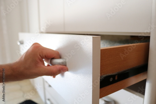 Man opens wood wardrobe drawer 