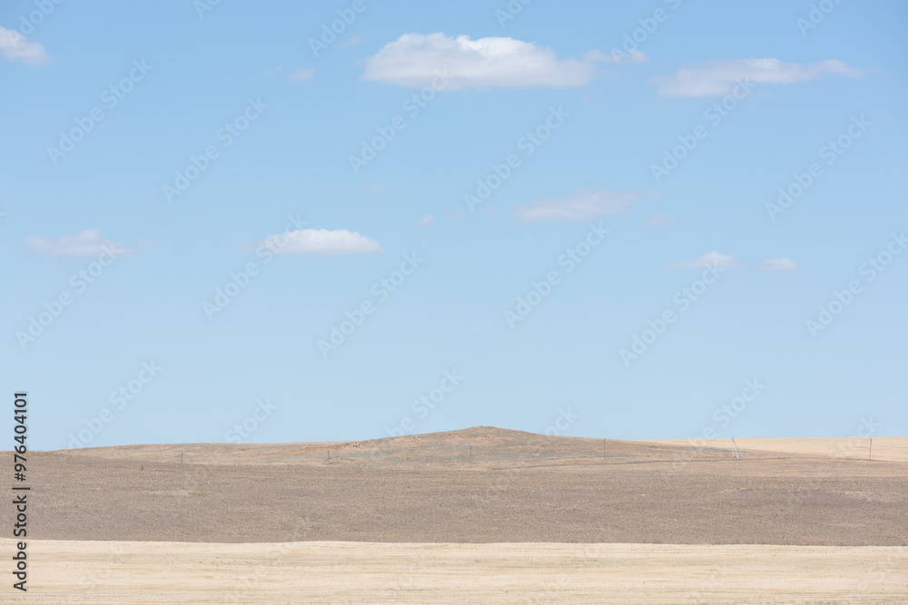 Low mountains in the steppe, blue sky and clouds Low mountains in the steppe, blue sky and clouds