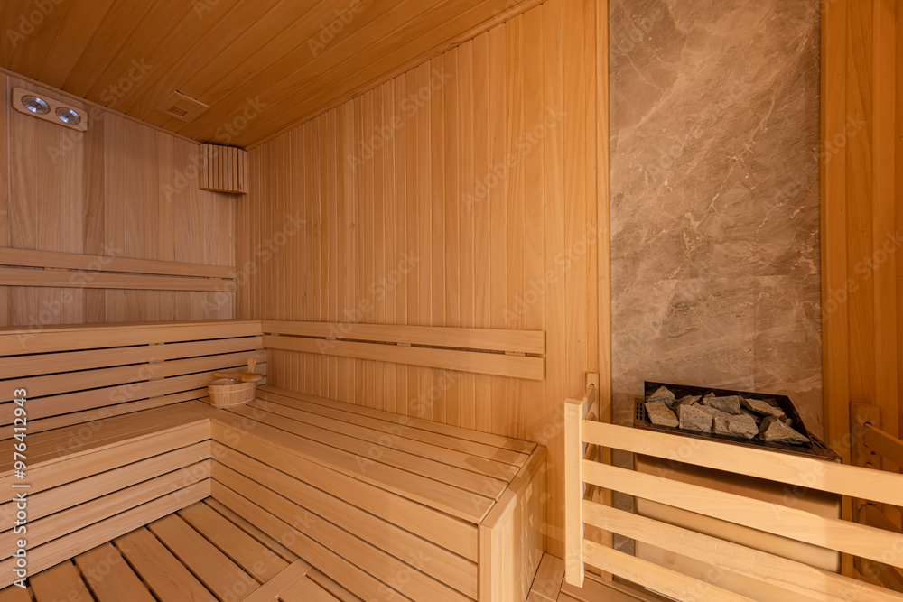 Interior of the Finnish sauna, classic wooden sauna with hot steam. Sauna room at hotel SPA center. Wooden interior baths, wooden benches and sun loungers sauna accessories, spa complex. Interior of the Finnish sauna, classic wooden sauna with hot steam. Sauna room at hotel SPA center. Wooden interior baths, wooden benches and sun loungers sauna accessories, spa complex.
