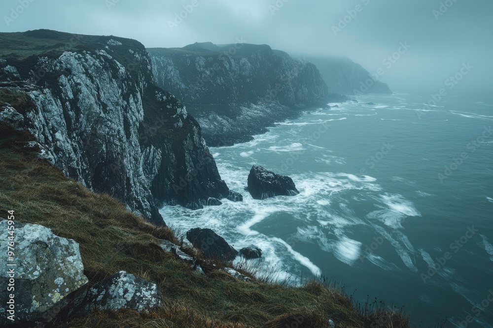 Obraz premium Dramatic Coastal Cliffs Under a Foggy Sky