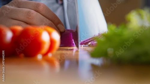 Woman chef slicing red onion for vegetarian lunch, vegan lifestyle, close up