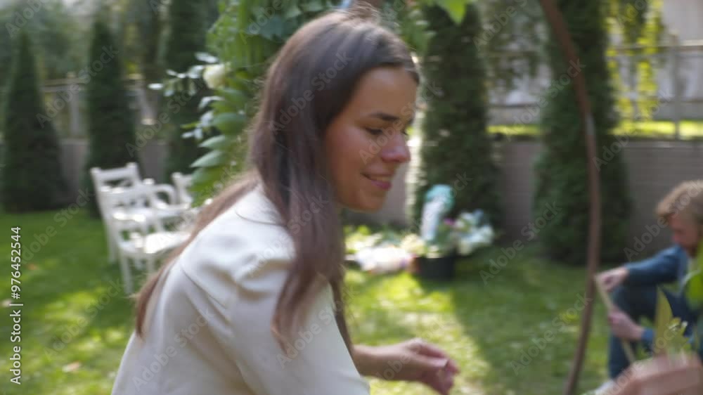 Professional florist at work. Young beautiful woman makes trendy modern bouquet of greenery different colors. Floral wedding arch design. Work concept. Decorator working outdoors in autumn.