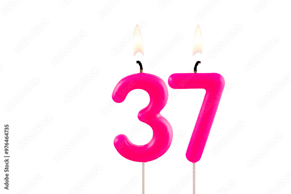 Pink number 37 birthday candle lit on white background Pink number 37 birthday candle lit on white background