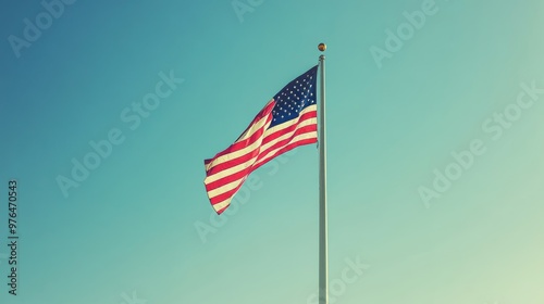 American Flag Pole Blowing in Wind with Blue Sky Background. America Independence Day July 4th Holiday